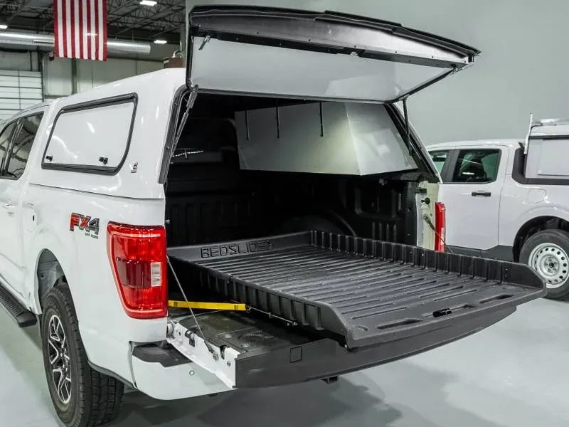 A BEDSLIDE extended from under a truck cap on a white Ford F-150 (BEDSLIDE photo)