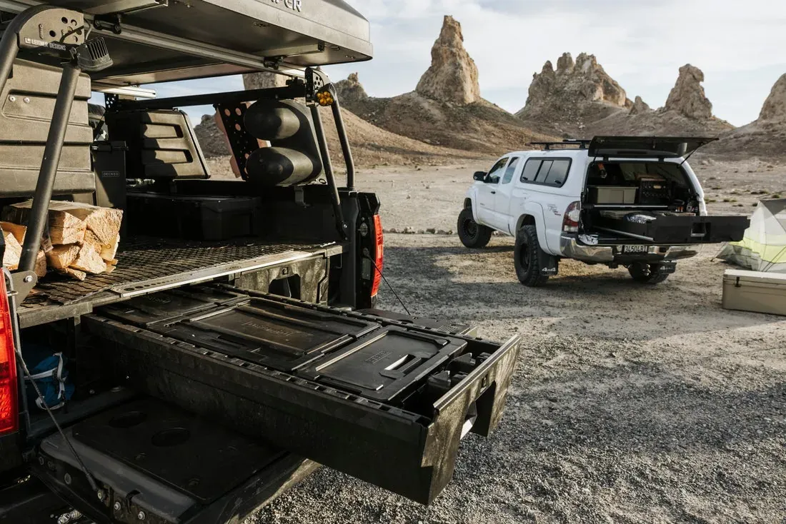 A truck with a topper open over DECKED drawers pulled out at camp (DECKED photo)