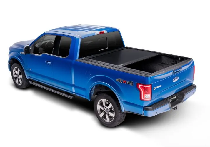 A blue Ford F-150 with a Retrax retractable cover partly open over the bed (Retrax photo)