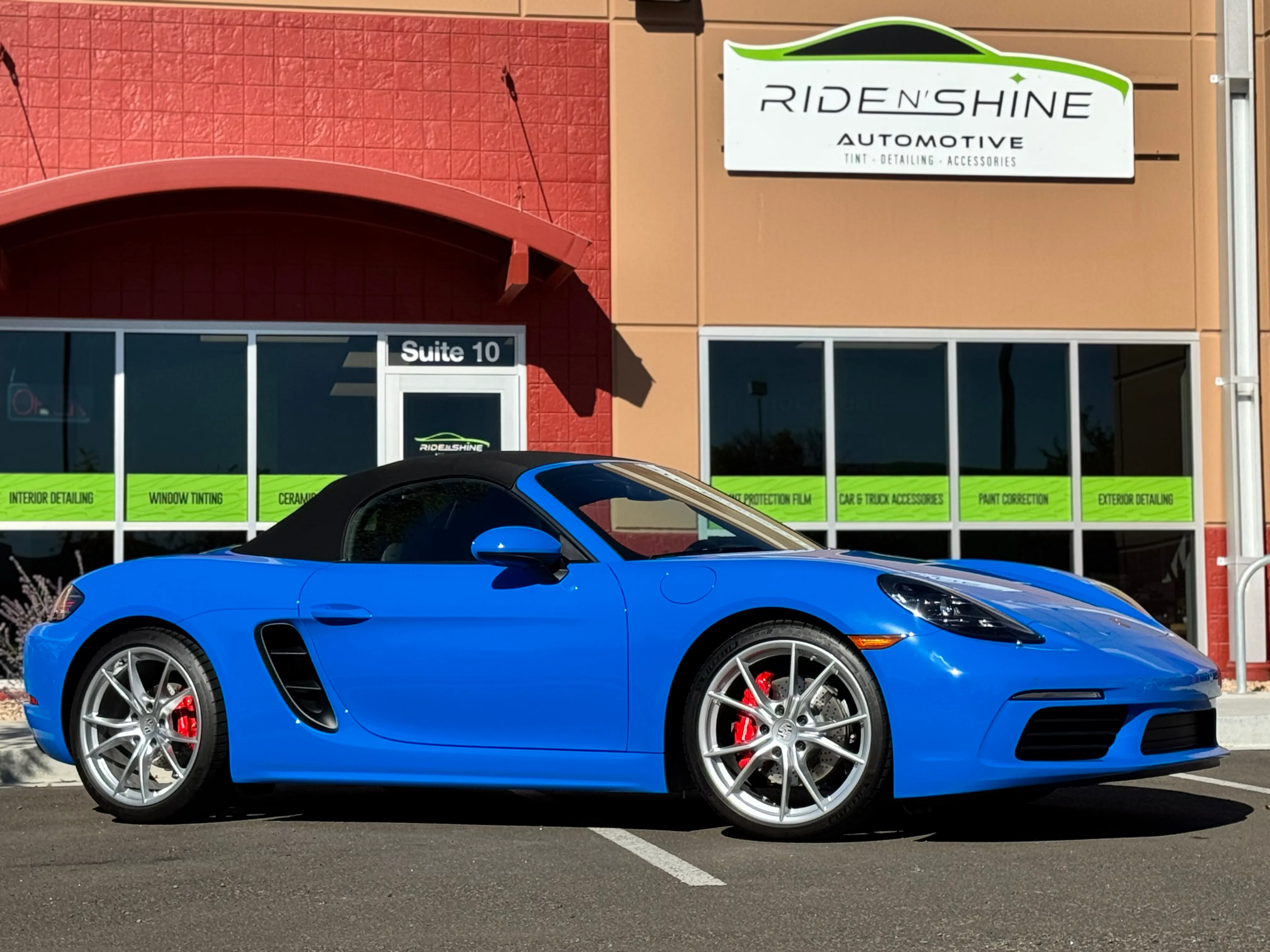 Blue Porsche 718 Boxster with fresh ceramic coating in a professional shop