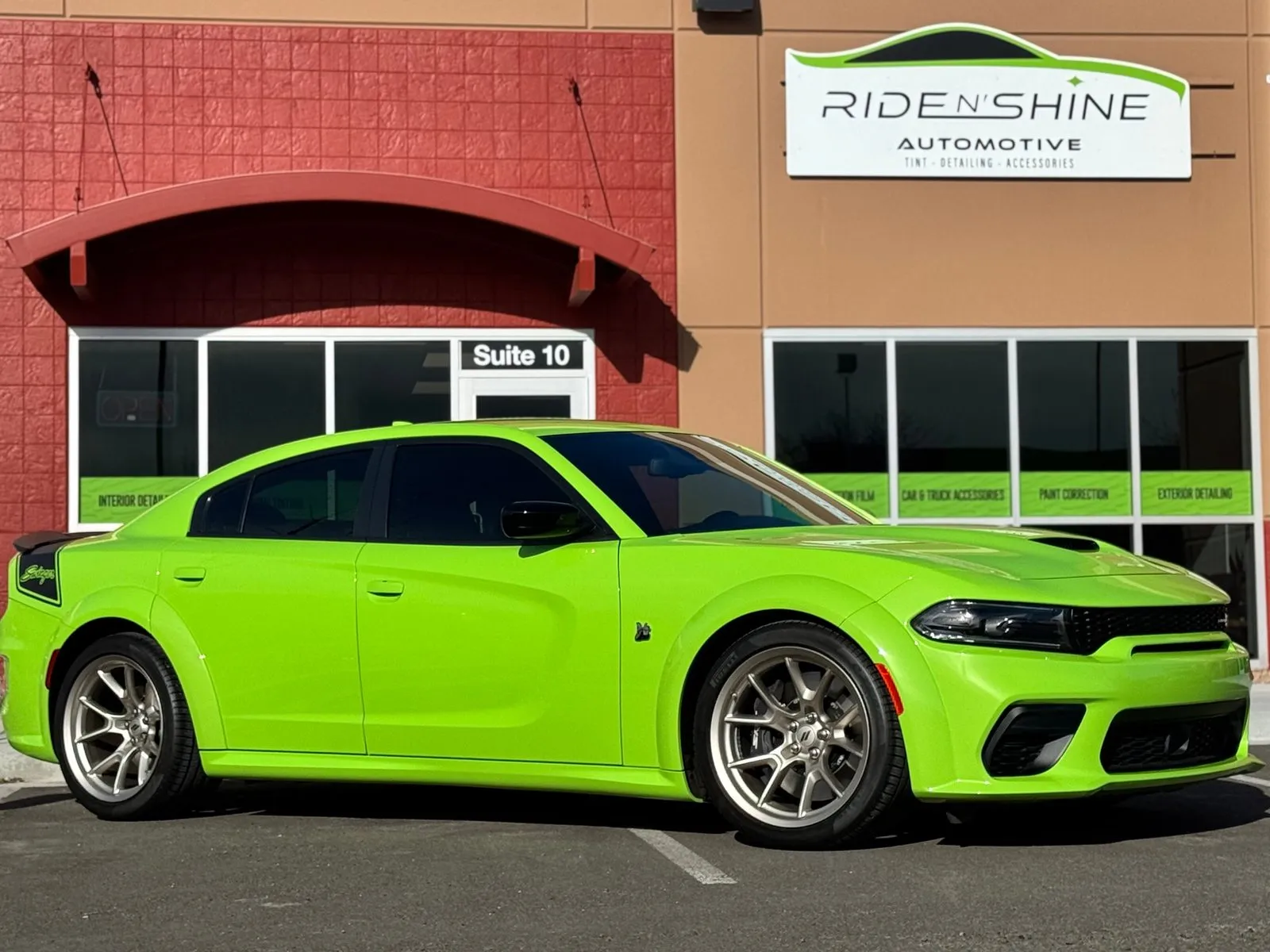 Bright green Dodge Charger parked outside the Ride N' Shine Automotive storefront after paint protection film and ceramic coating work
