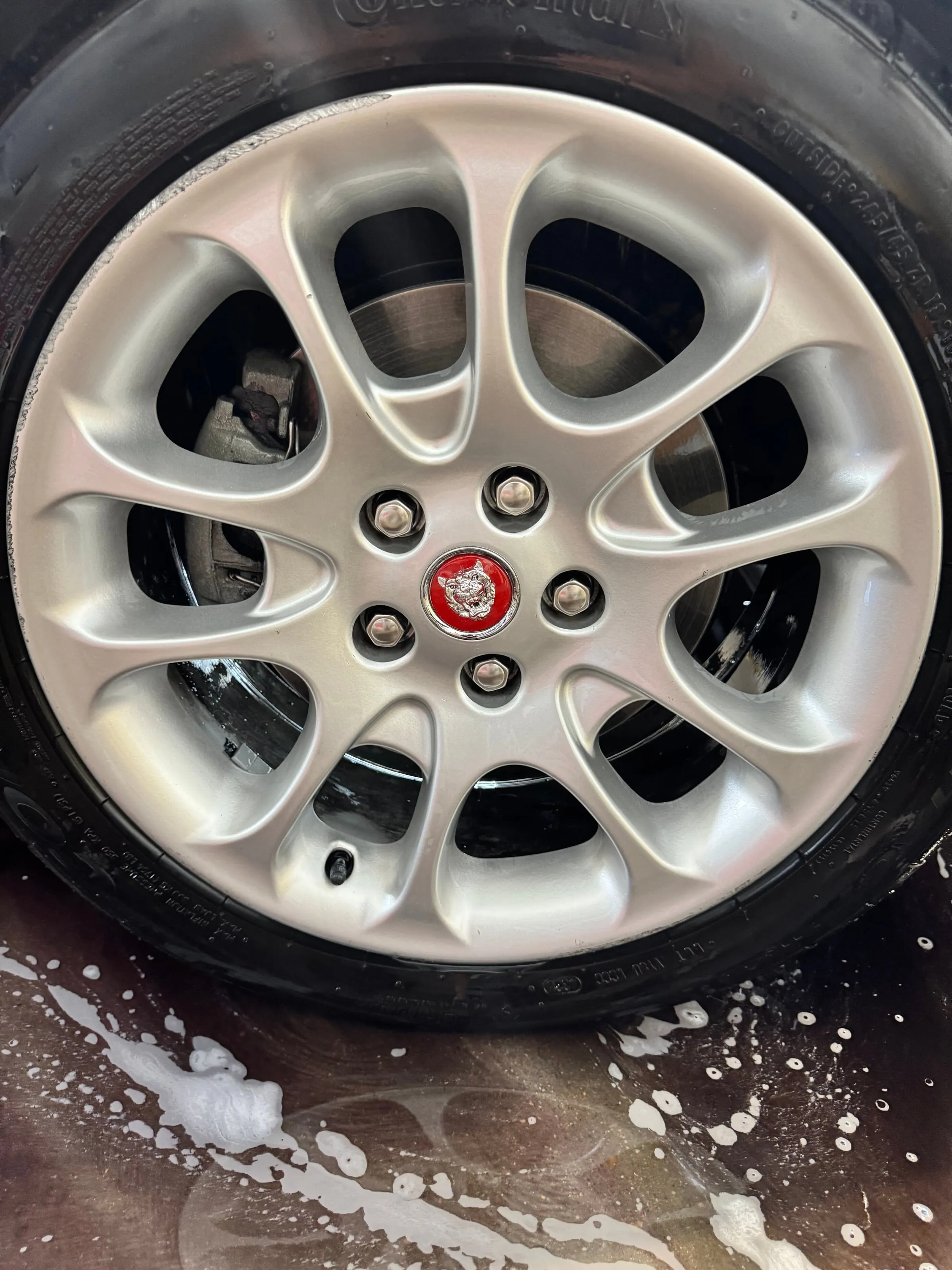 The same wheel cleaned, suds still on the floor beside it