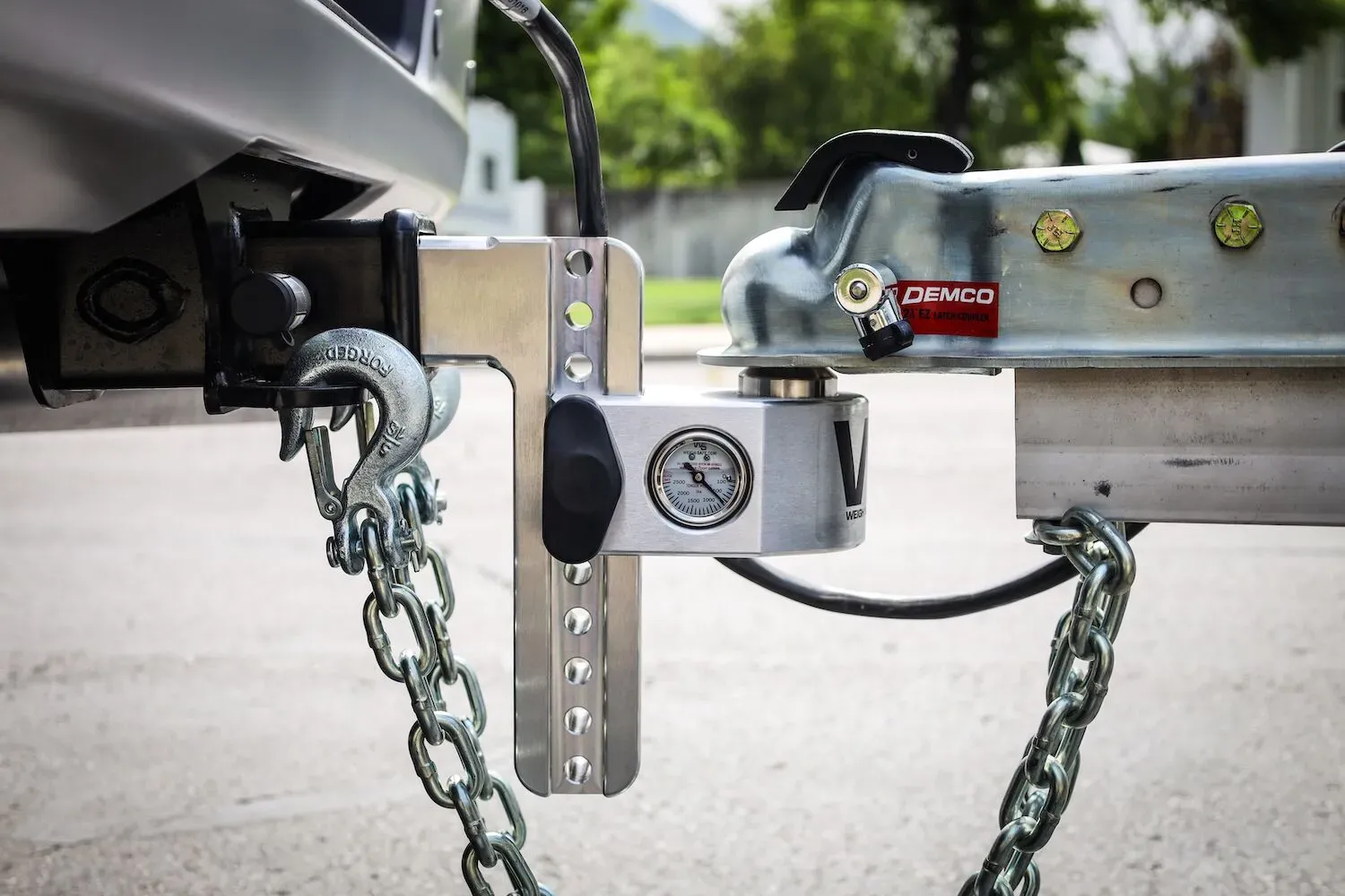 A Weigh Safe adjustable drop hitch coupled to a trailer, with the tongue weight gauge reading from the side of the ball mount