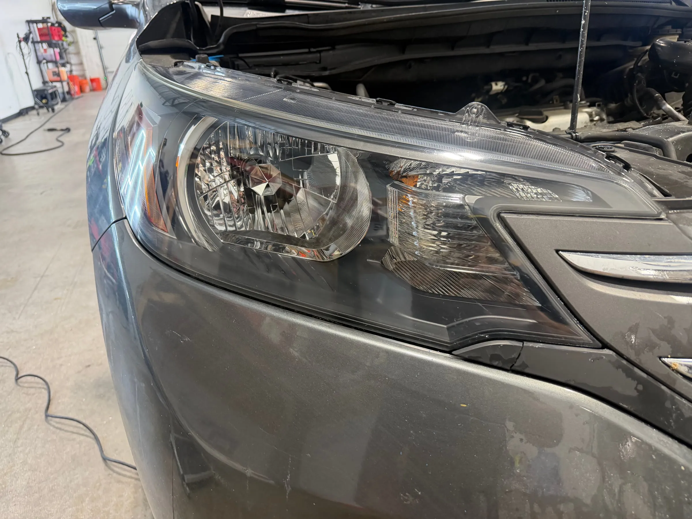 The same CR-V headlight after restoration, the lens clear and the reflector visible through it