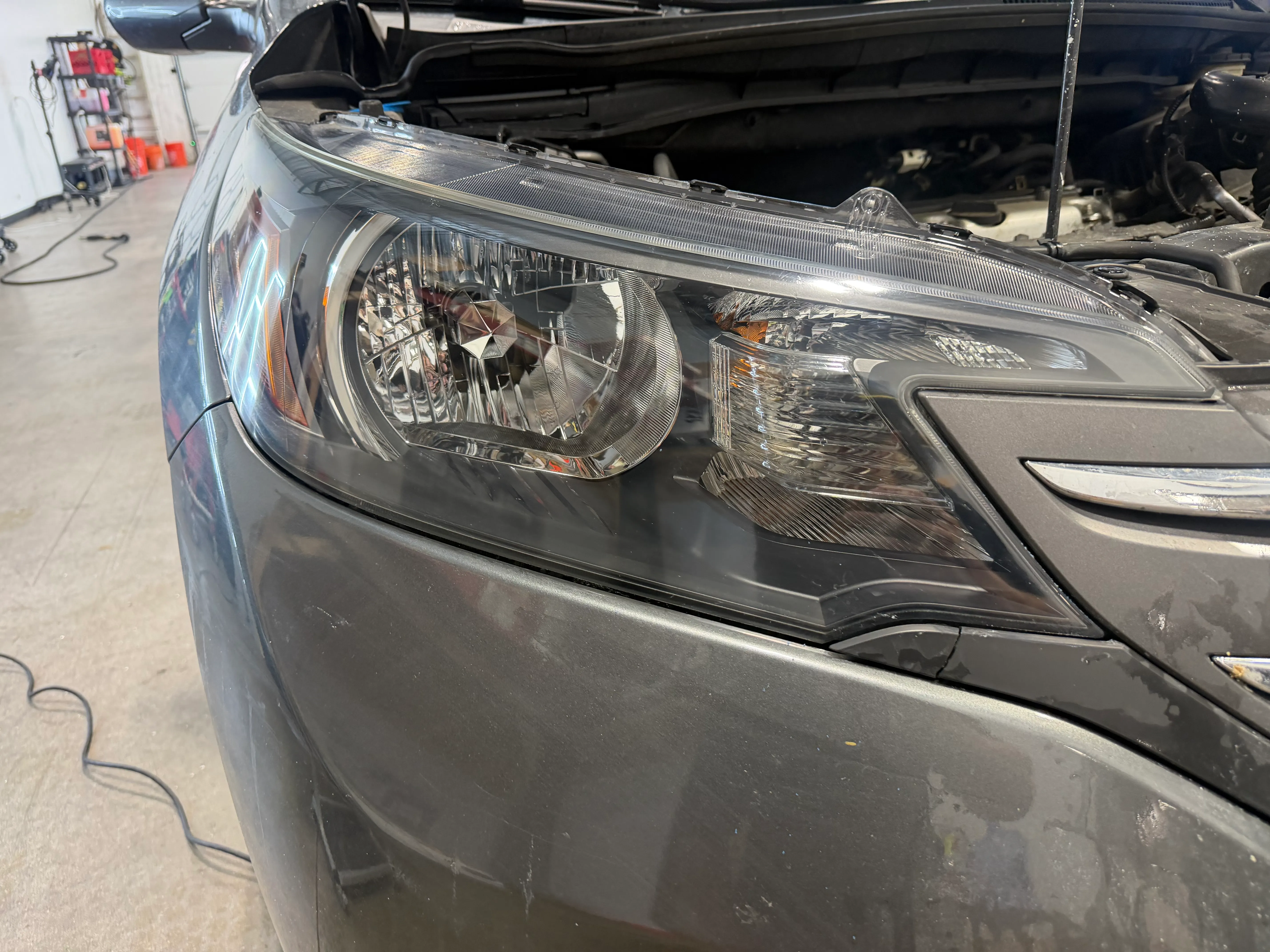 The same CR-V headlight after restoration, the lens clear and the reflector visible through it