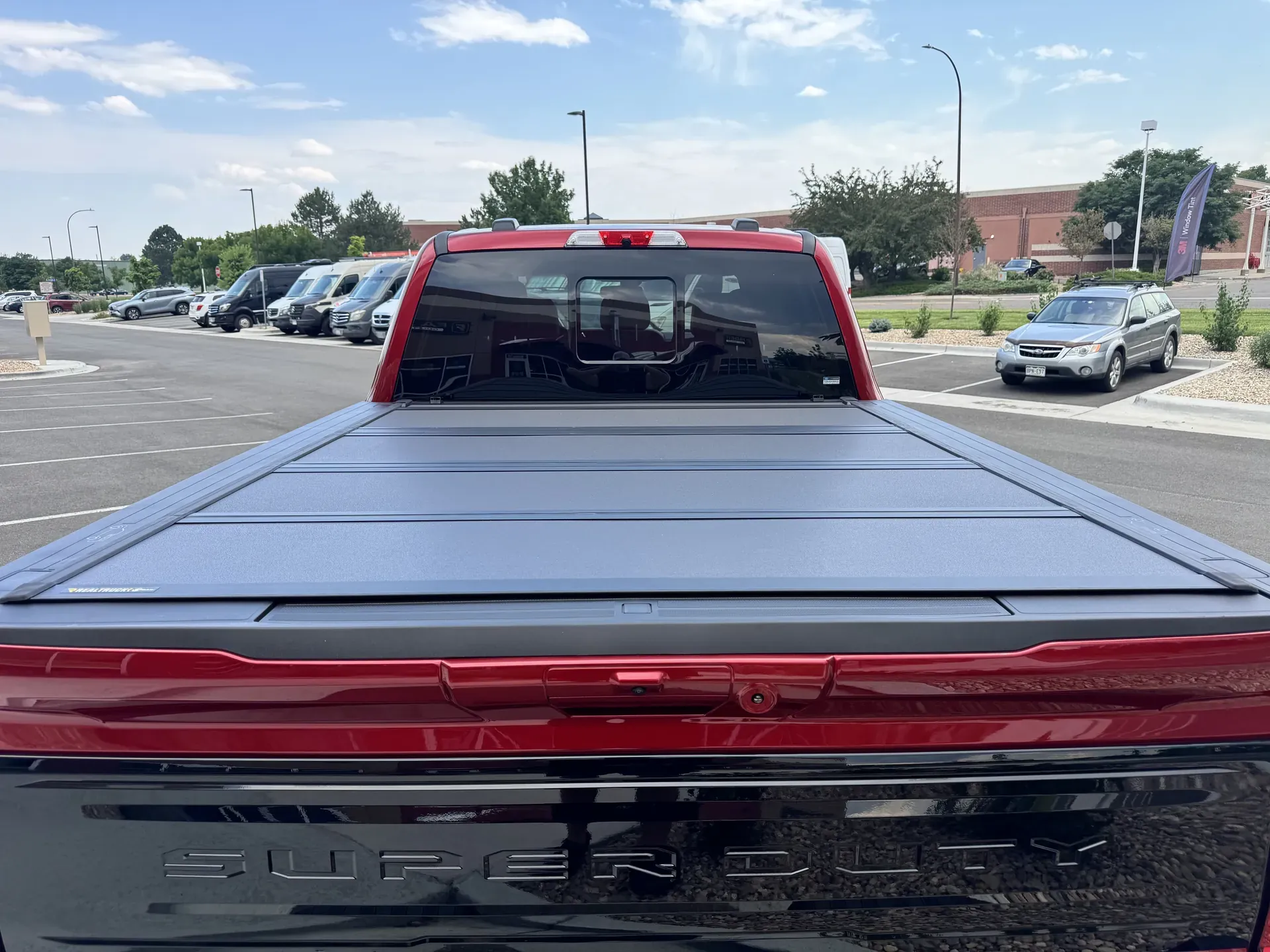 A red Ford F-250 with a BAKFlip MX4 tonneau cover, photographed at Ride N' Shine