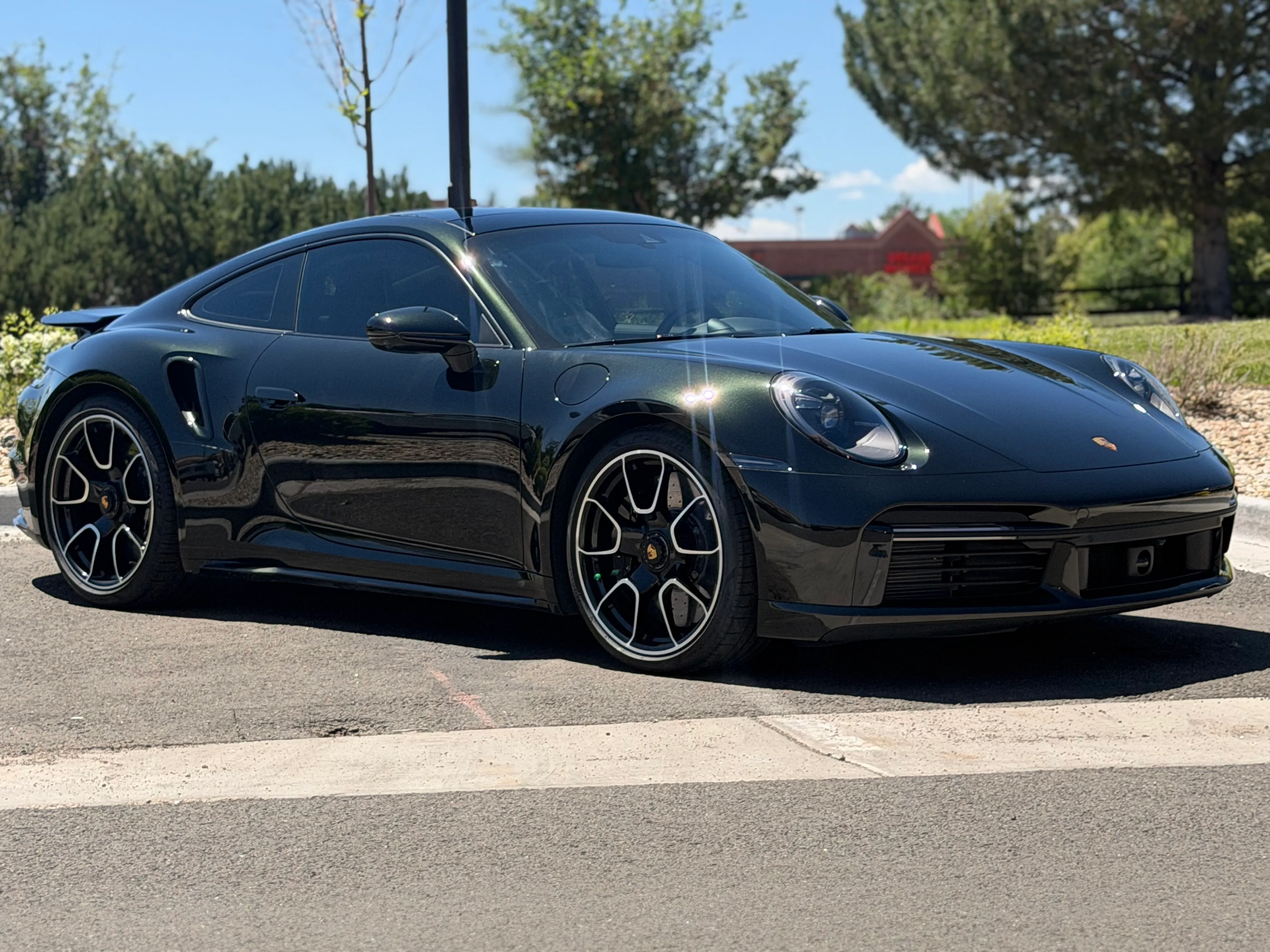 Dark green Porsche 911 Turbo S with paint protection film outside the shop