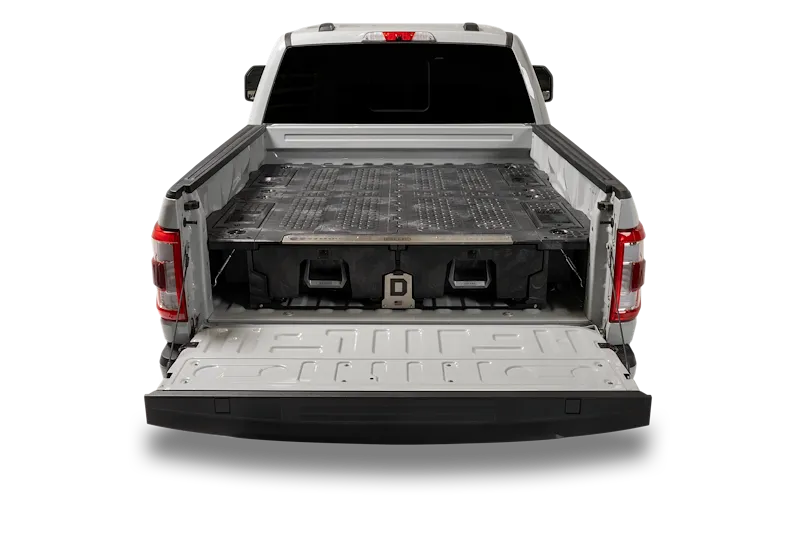 A Ford F-150 with the tailgate down, showing a DECKED drawer system filling the bed with a flat load deck over two pull-out drawers
