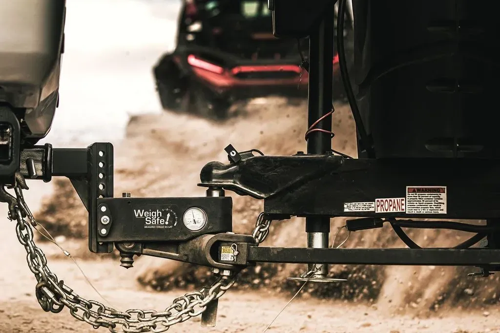 A Weigh Safe True Tow weight distribution hitch with its tongue weight gauge, towing on a dirt road (Weigh Safe photo)